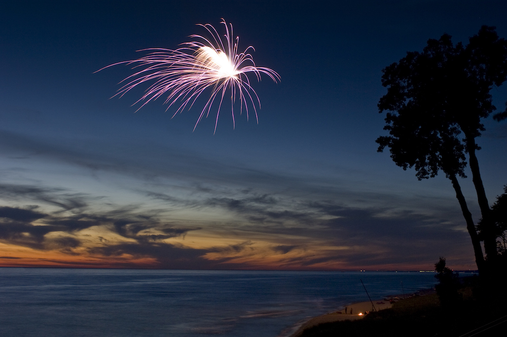 fireworks over water at dusk